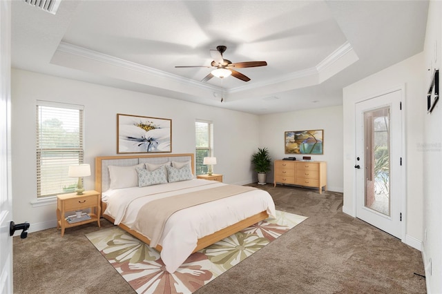 carpeted bedroom featuring ceiling fan, a raised ceiling, ornamental molding, and multiple windows