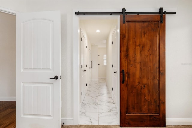 hallway featuring a barn door and light hardwood / wood-style flooring