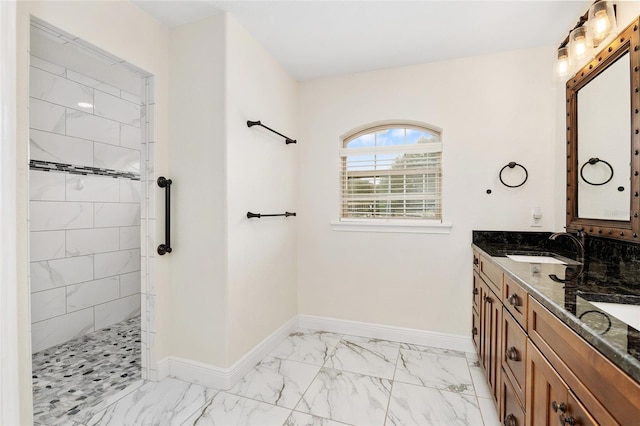 bathroom with a tile shower and vanity