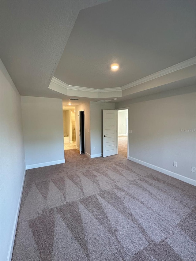 carpeted empty room with crown molding and a tray ceiling