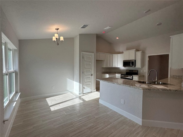 kitchen featuring an inviting chandelier, white cabinets, sink, appliances with stainless steel finishes, and kitchen peninsula