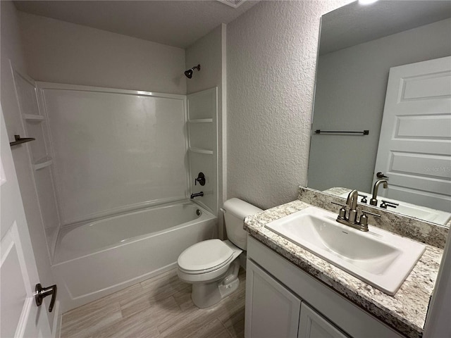 full bathroom featuring vanity, hardwood / wood-style flooring, toilet, a textured ceiling, and shower / bath combination