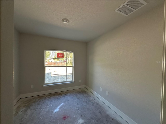 spare room with concrete flooring and a textured ceiling