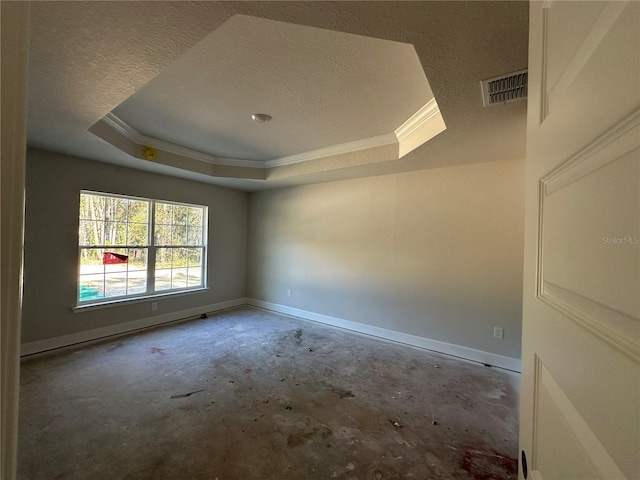 empty room with a tray ceiling, crown molding, and concrete flooring