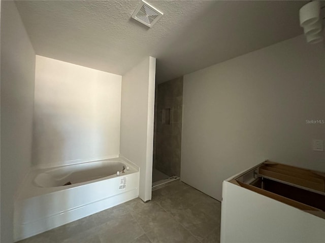 bathroom with independent shower and bath and a textured ceiling