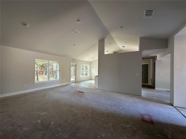 spare room with lofted ceiling and concrete flooring