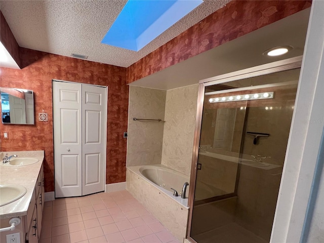 bathroom featuring a skylight, plus walk in shower, tile patterned floors, a textured ceiling, and vanity