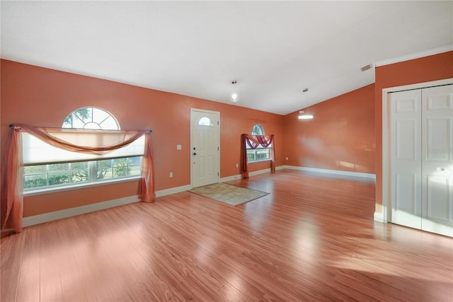 foyer entrance featuring vaulted ceiling and light hardwood / wood-style flooring