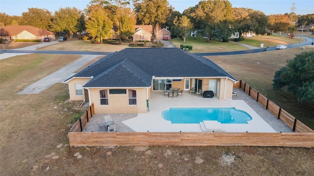 view of swimming pool with a diving board and a patio