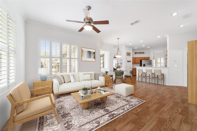 living room featuring hardwood / wood-style floors and ceiling fan