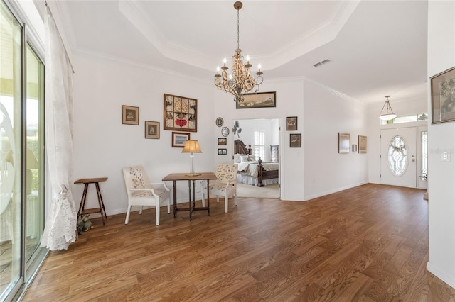 interior space with hardwood / wood-style floors, crown molding, a raised ceiling, and a healthy amount of sunlight