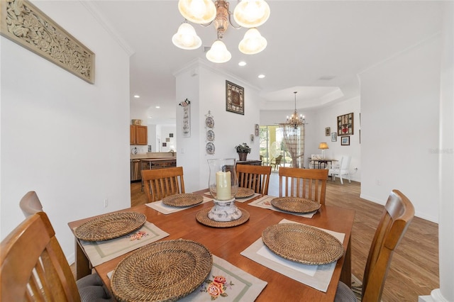 dining area featuring a notable chandelier, wood-type flooring, and crown molding