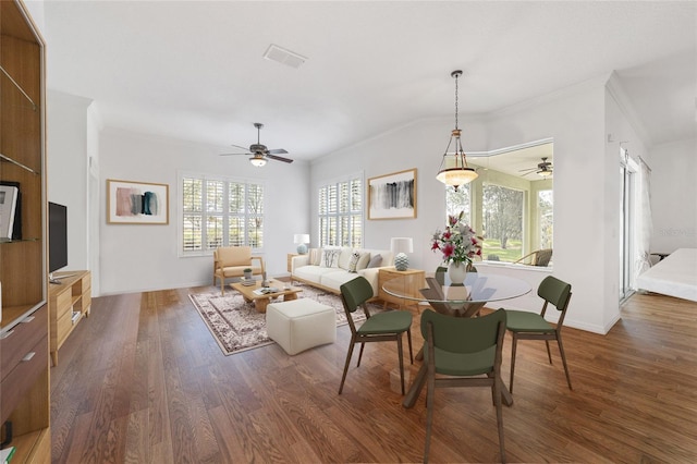 dining space with ceiling fan, dark hardwood / wood-style floors, and ornamental molding