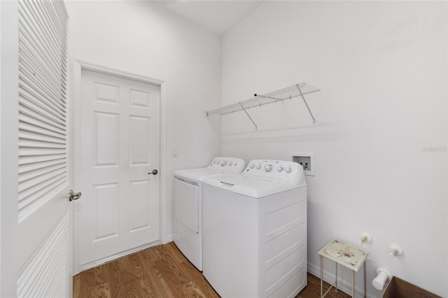 clothes washing area with washer and dryer and wood-type flooring