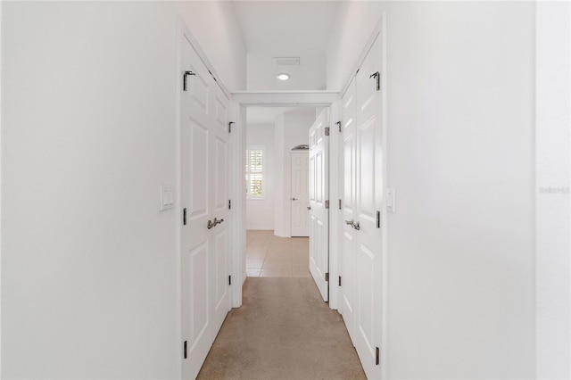 hallway featuring light colored carpet