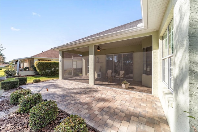 view of patio featuring a sunroom and ceiling fan