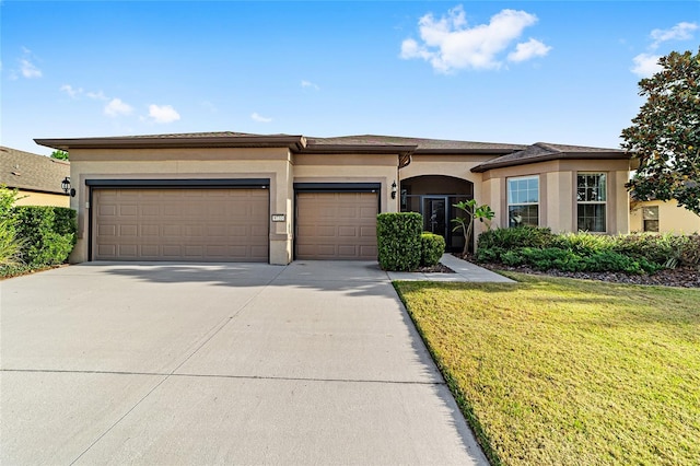 prairie-style home with a garage and a front lawn