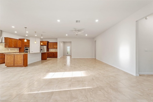 kitchen with tasteful backsplash, stainless steel appliances, ceiling fan, decorative light fixtures, and a large island