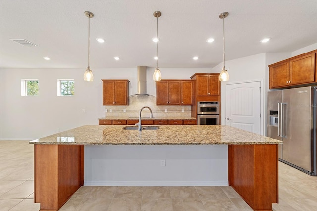 kitchen with a large island, wall chimney exhaust hood, stainless steel appliances, and hanging light fixtures