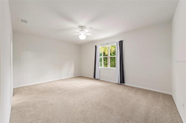 carpeted empty room with ceiling fan and a textured ceiling