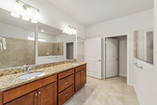 bathroom featuring a tile shower, vanity, and tile patterned floors