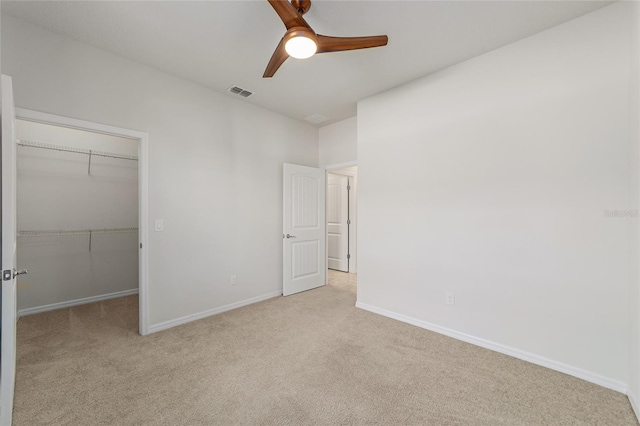 unfurnished bedroom featuring ceiling fan, a closet, and light colored carpet