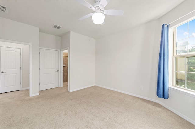 unfurnished bedroom featuring ceiling fan and light colored carpet