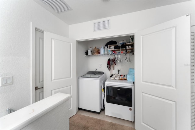 washroom featuring laundry area, visible vents, independent washer and dryer, and light tile patterned flooring