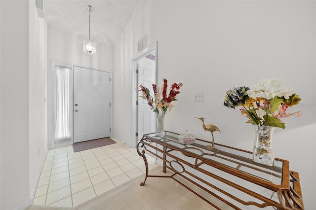 tiled foyer featuring an inviting chandelier