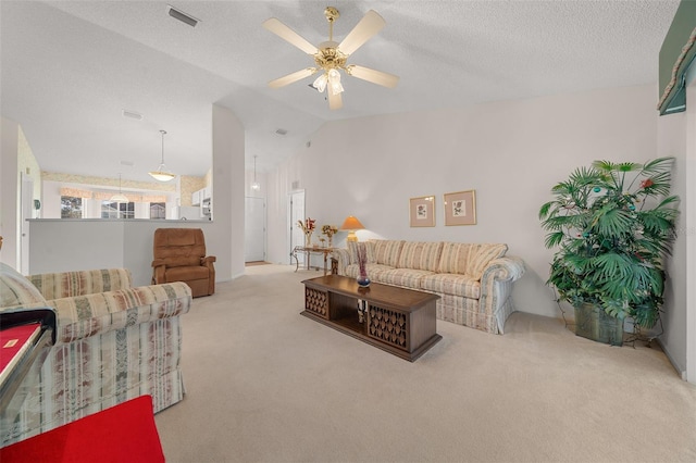 carpeted living room with ceiling fan, lofted ceiling, and a textured ceiling