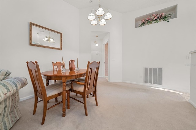 dining area featuring carpet flooring, a high ceiling, and an inviting chandelier