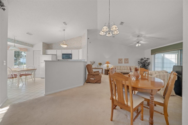 carpeted dining room featuring ceiling fan with notable chandelier, a textured ceiling, and lofted ceiling