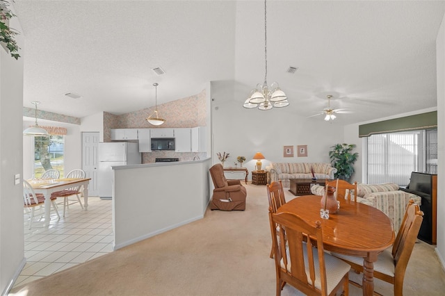 carpeted dining area with ceiling fan with notable chandelier, a textured ceiling, and vaulted ceiling