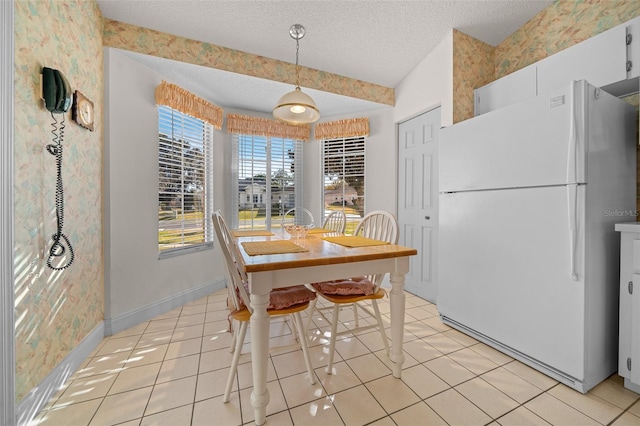 dining area featuring light tile patterned floors and a textured ceiling