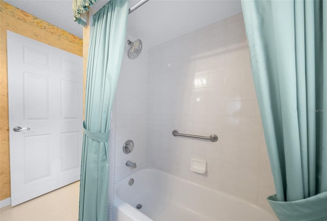 bathroom with shower / bath combination with curtain and a textured ceiling