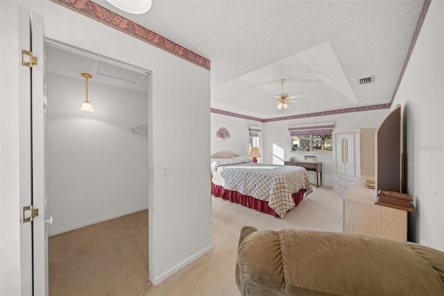 bedroom featuring ceiling fan, light carpet, and a textured ceiling