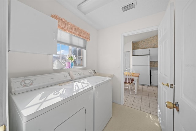 laundry area featuring separate washer and dryer, light tile patterned floors, and a textured ceiling