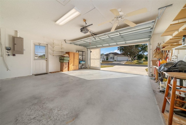 garage featuring electric panel, a garage door opener, and ceiling fan