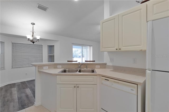 kitchen featuring white appliances, wood-type flooring, sink, hanging light fixtures, and kitchen peninsula