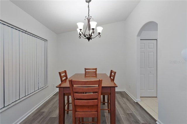 dining space featuring a chandelier, wood-type flooring, and lofted ceiling