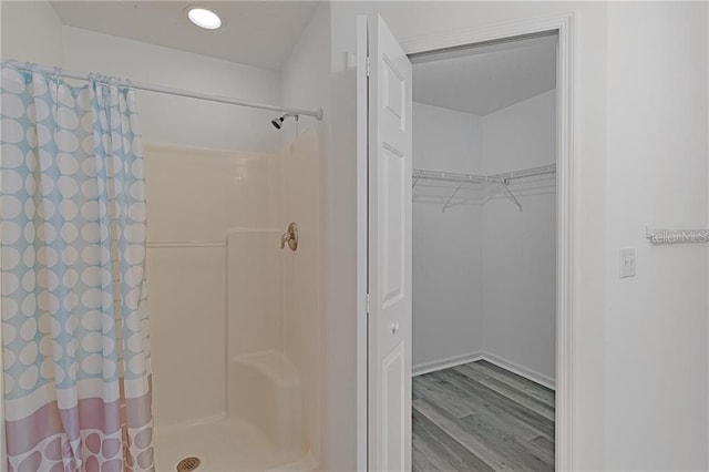 bathroom with a shower with curtain and wood-type flooring