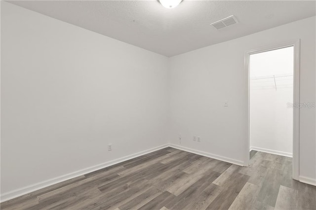 empty room featuring hardwood / wood-style floors and a textured ceiling