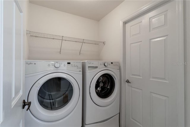 clothes washing area with separate washer and dryer