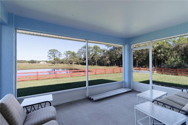 sunroom featuring a water view