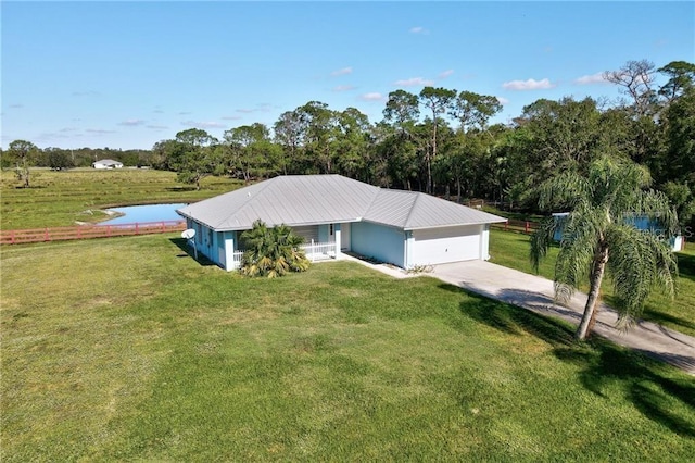 view of front facade with a front yard, a water view, and a garage