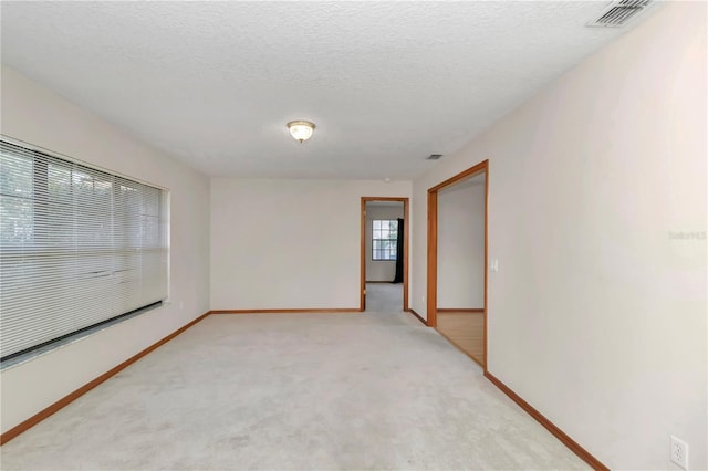 carpeted spare room with a textured ceiling