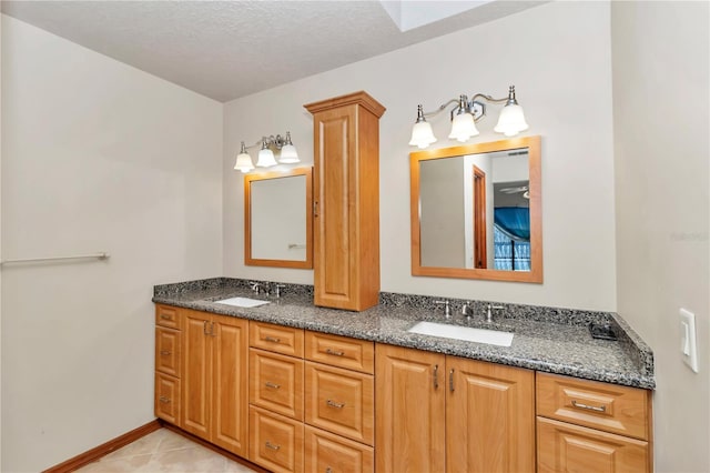 bathroom featuring tile patterned floors, vanity, and a textured ceiling