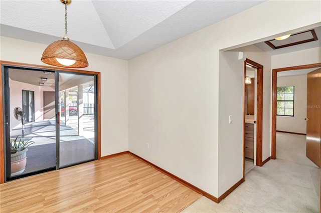 spare room featuring a textured ceiling and light wood-type flooring