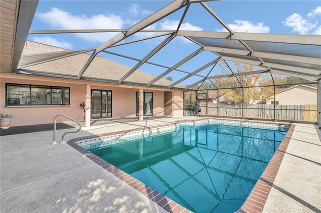 view of swimming pool featuring glass enclosure and a patio