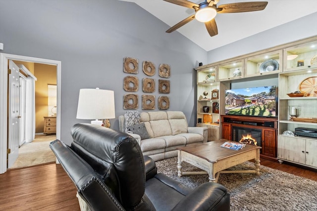 living room featuring ceiling fan, lofted ceiling, and dark wood-type flooring